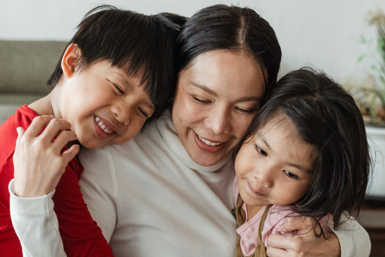 Mother hugging two children