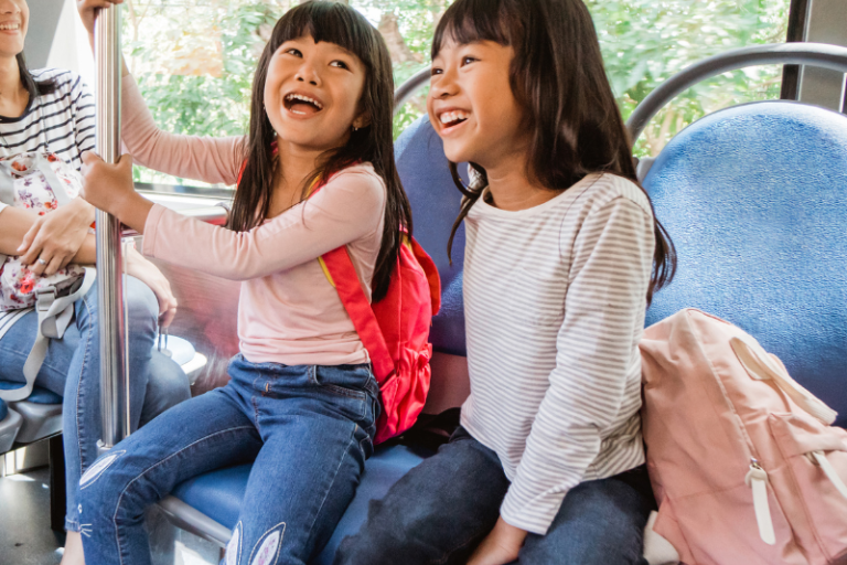 two children on public transportation smiling