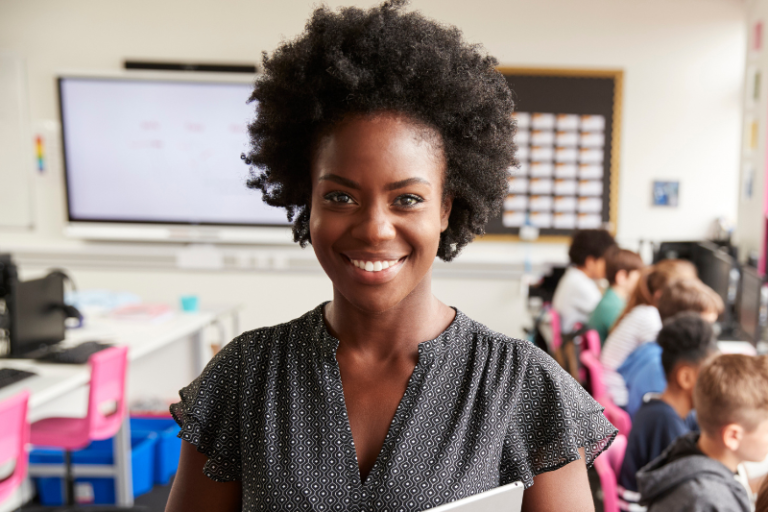 teacher in classroom setting with students at computers