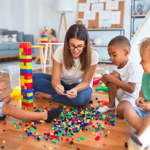 Three children and an adult playing with blocks.