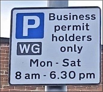 Parking sign saying business permit holders and times for parking