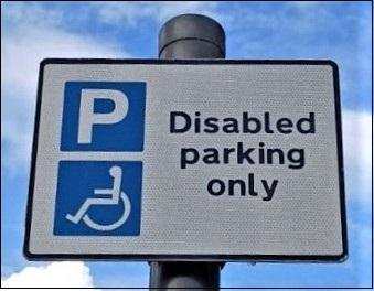 Parking sign saying disabled parking only, showing a P in a blue square and person in a wheelchair
