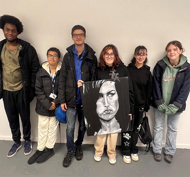 Image of young people posing with portrait of Amy Winehouse