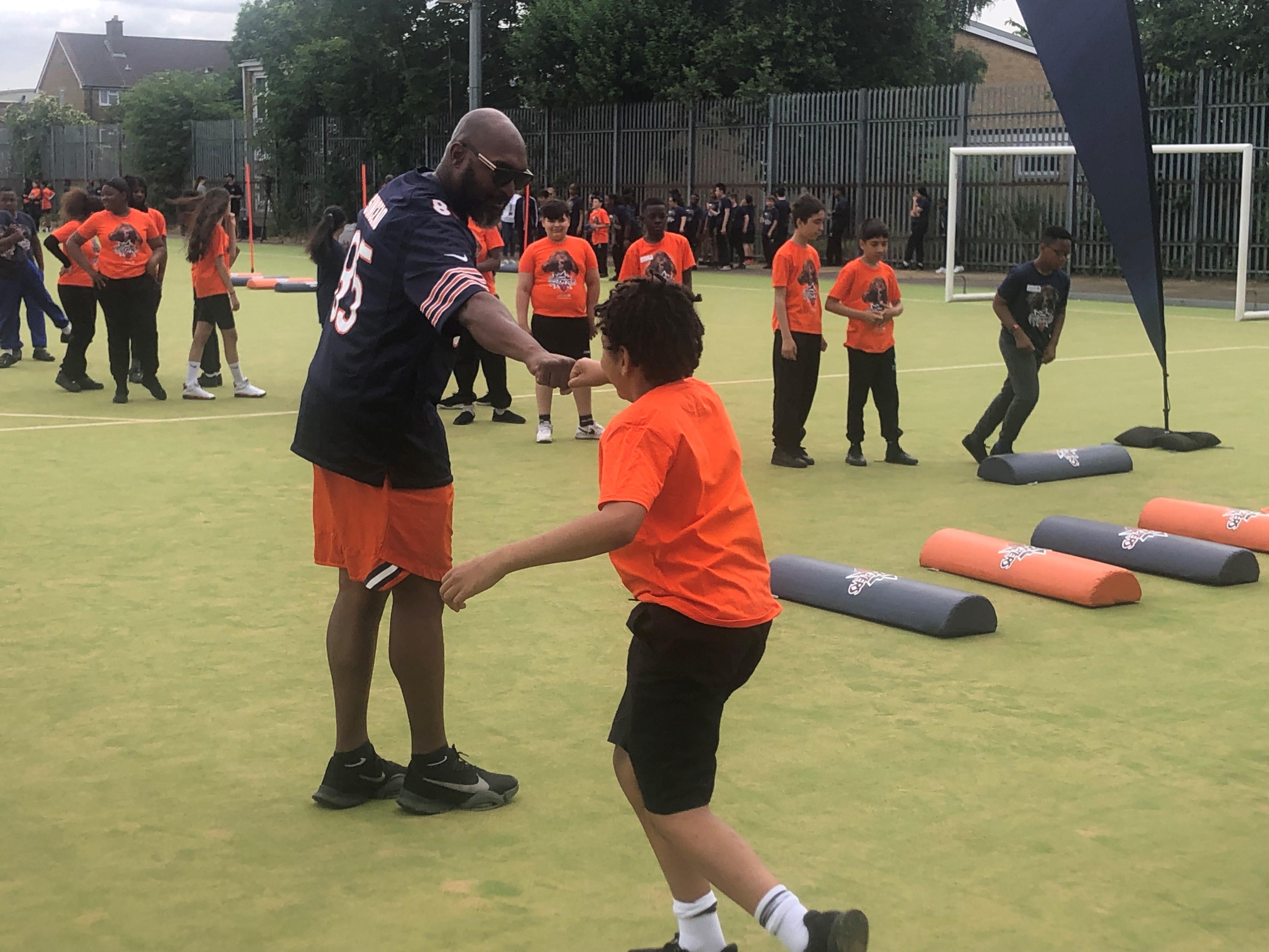 The pic is of ex Chicago Bears & Philadelphia Eagles tight end/TE Kaseem Sinceno giving a fist bump to a young pupil during the 'Mini Monsters' camp at Duke's Aldridge Academy