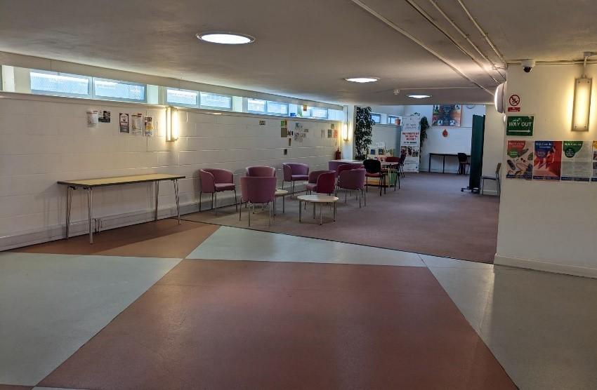 A space within Northumberland Park Resource Centre. There is an open space and an area with some tables and chairs