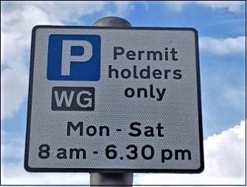 Parking sign saying permit holders, showing a P in a blue square and times for parking