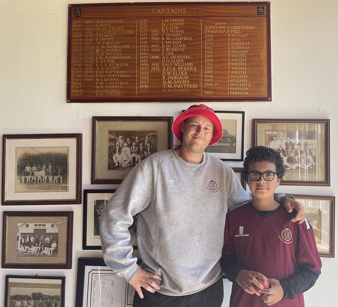 young person standing next to cricket coach